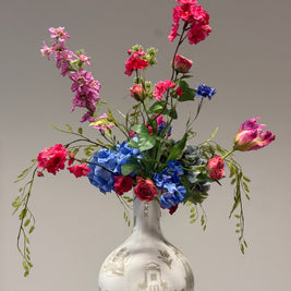 Kleurrijk zijden bloemen boeket in de kleuren roze,fuchsia,blauw en groen takken. 