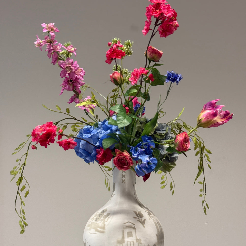 Kleurrijk zijden bloemen boeket in de kleuren roze,fuchsia,blauw en groen takken. 