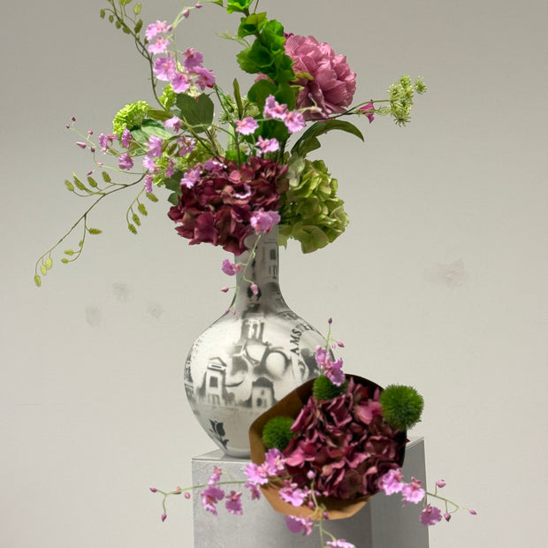 een combinatie van 3 zijdenbloemen de roze hortensia de roze orchidee en groene distel