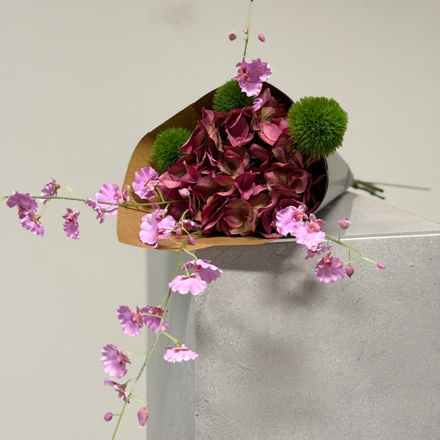 kadotip drie zijden bloemen gecombineerd in mooi bosje. Roze hortensia met orchidee en distel.
